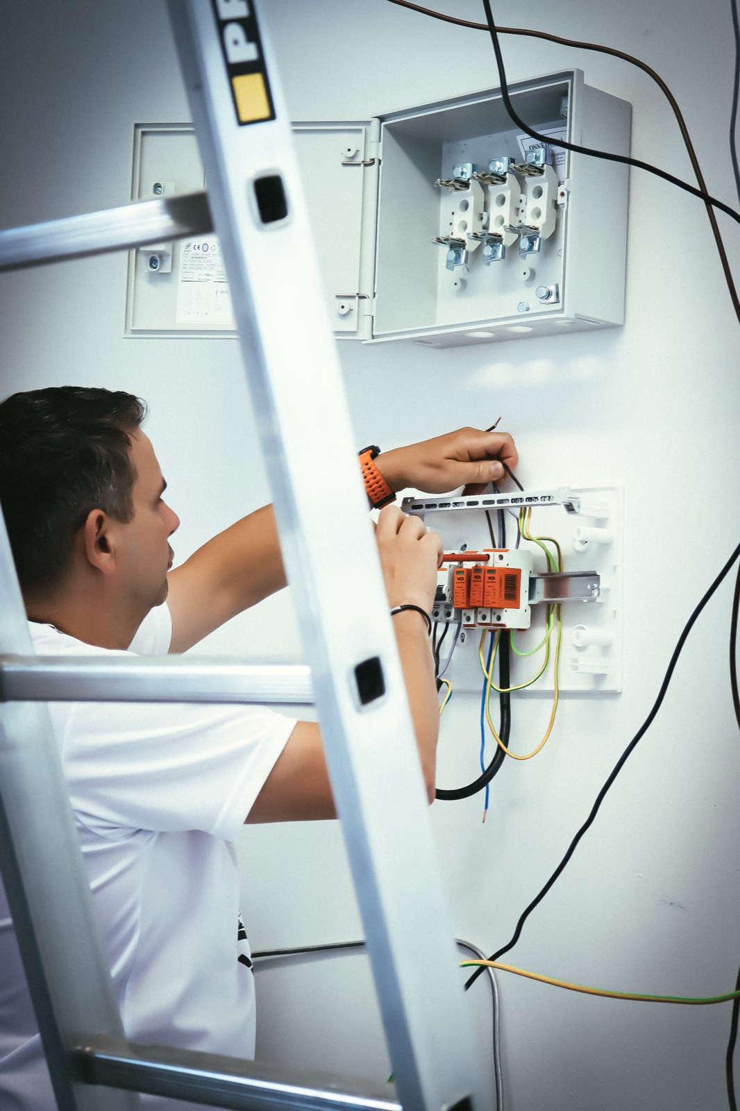 Elektrikář samostatně pracuje na instalaci u stropu